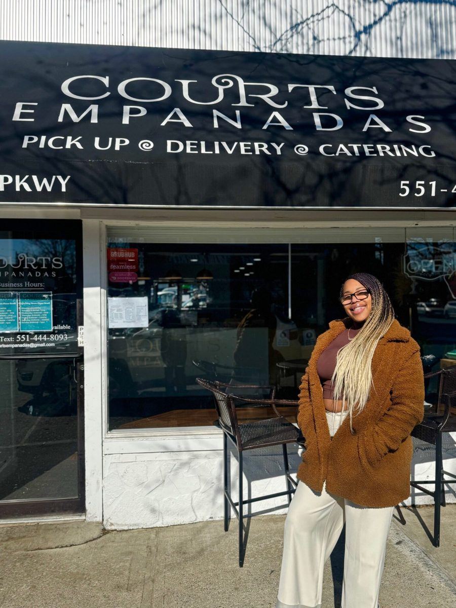 Courtney outside the Courts Empanadas storefront on Ampere Parkway